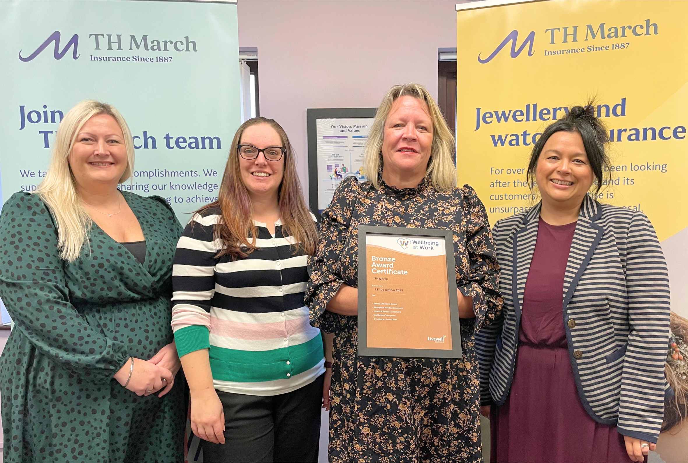 Employees at TH March Smiling whilst holding their bronze certificate